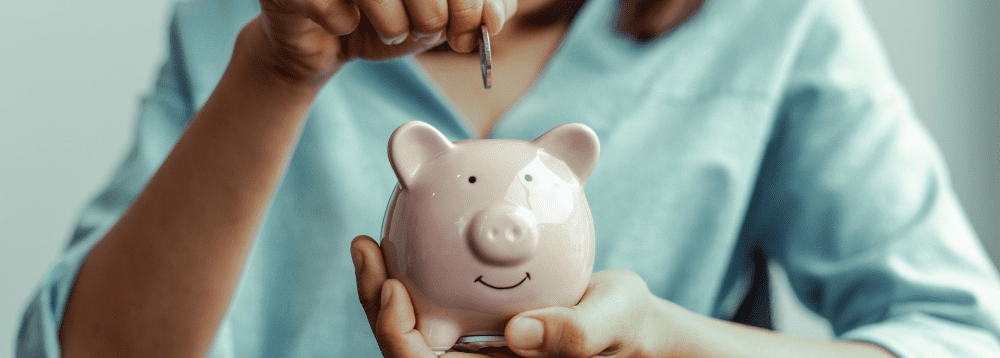 A person placing money into a piggy bank.