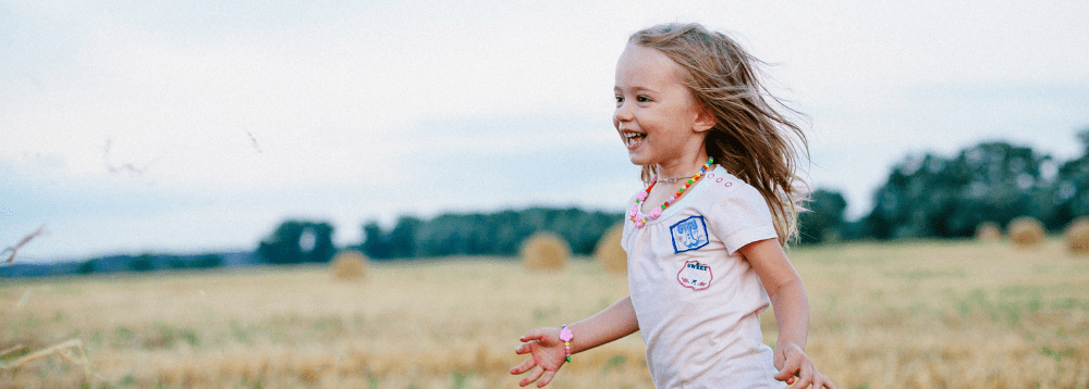 A young girl running through a field. 