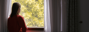 A picture of a woman staring out of the window. 